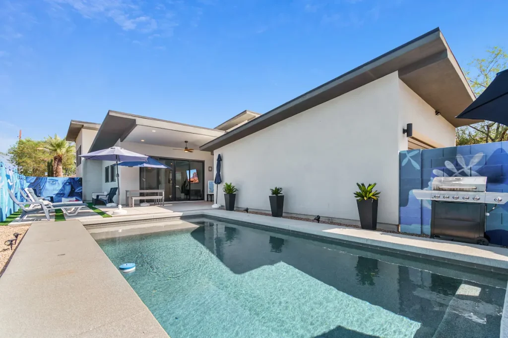 The outdoor backyard of the downtown Phoenix home with a pool, BBQ and shaded lounge areas