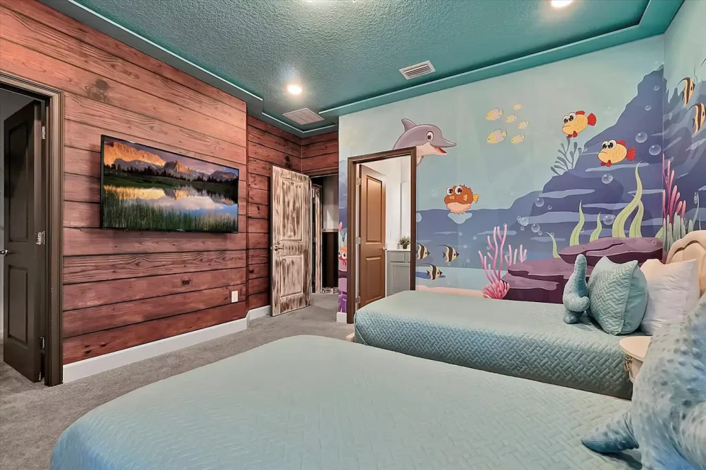 One of the children's bedrooms of the vacation rental with two twin beds and decorative walls. 